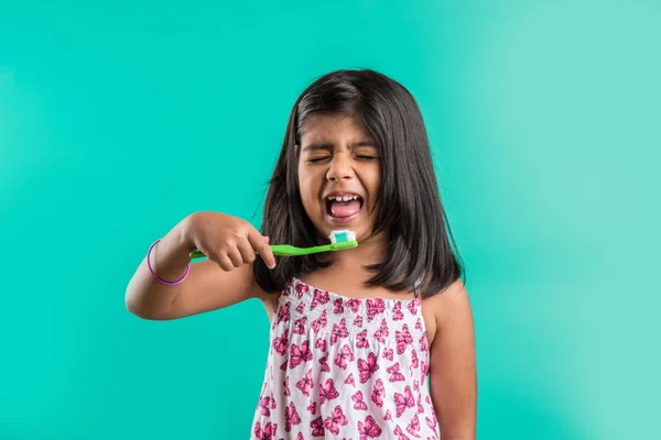 crying indian girl and tooth brush, sad indian girl and brushing, asian girl with tooth brush and paste, indian girl caring her teeth, indian girl and oral care, indian girl and bed time brushing