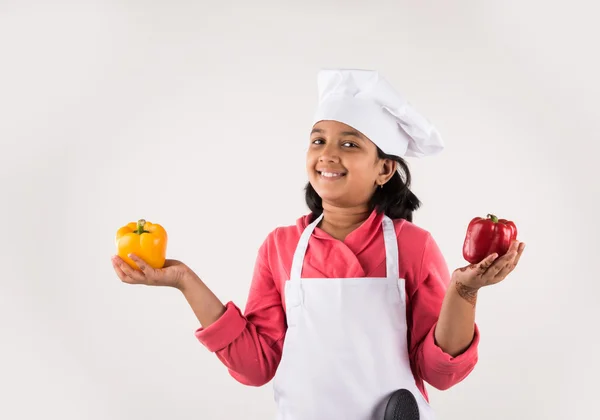 indian small girl chef with capsicum, isolated on white background, indian little chef, asian girl chef