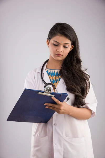 Jovem muito índio feminino médico com cartão de saúde ou escrita pad, mulher asiática e escrita pad, isolado em fundo cinza — Fotografia de Stock