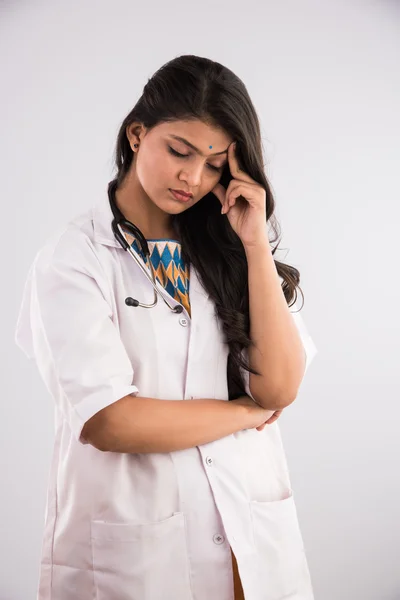 Indisk kvinnlig läkare med huvudvärk eller huvud värk, migrän eller under stress, isolerad över grå bakgrund — Stockfoto