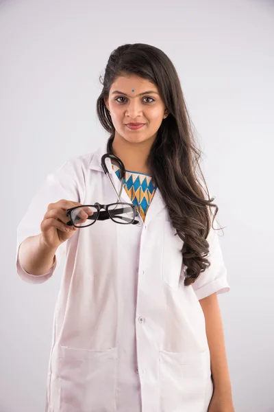 En indisk kvinnlig sjuksköterska med en speciell eller glasögon eller öga slitage och öga test diagram i bakgrunden, isolerad på grå bakgrund — Stockfoto