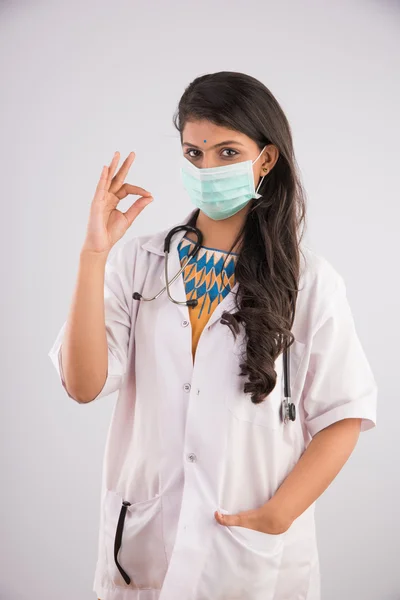 Närbild porträtt av en kvinnlig läkare bär en medicinsk mask och OK tecken, Asiatisk kvinnlig läkare och ansiktsmask eller medicinsk mask, hygien och säkerhet koncept, isolerad på grå bakgrund — Stockfoto