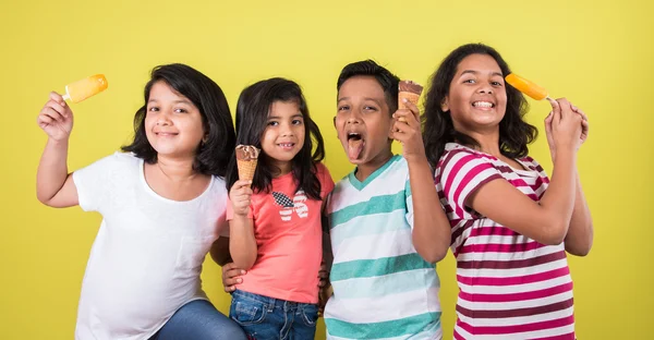 Cuatro lindos niños indios comiendo helado, chicas asiáticas y niño y helado, aislados sobre fondo verde — Foto de Stock