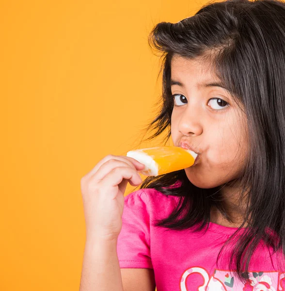 Gelukkig weinig Indiase meisje met een ijs snoep of ijs cream in de hand, Aziatisch meisje en ijs — Stockfoto