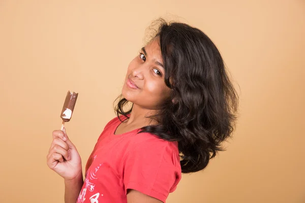 아이스크림이나 아이스크림을 먹는 인도 소녀, 아시아 소녀와 아이스크림 이나 아이스크림, 갈색 배경에 고립 된, 아이스크림을 즐기는 10 살 인도 소녀 — 스톡 사진