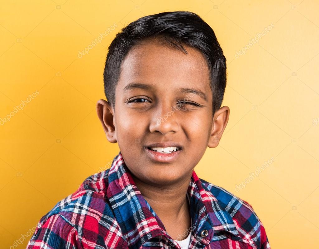 Portrait of indian little boy winking isolated on yellow background Stock  Photo by © 115284868
