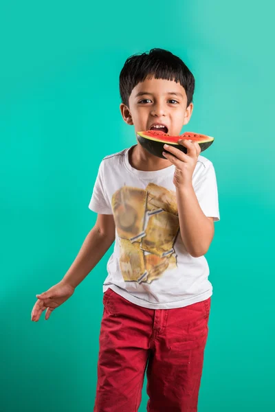 Μικρό ινδικό αγόρι τρώει καρπούζι απομονώνεται σε πράσινο, ασιατικό αγόρι τρώει καρπούζι, 4 χρονών χαρούμενο Ινδικό αγόρι τρώει καρπούζι, αγόρι με καρπούζι — Φωτογραφία Αρχείου