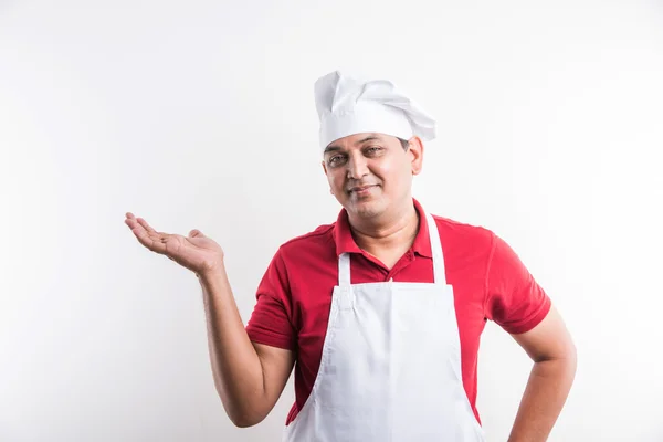 Portrait of handsome indian male chef introducing something , asian male chef presenting something, isolated over white background — Stock Photo, Image