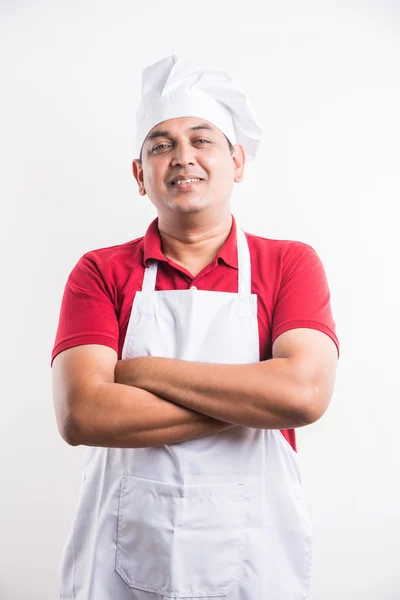 Portrait of handsome and cheerful Indian male chef in uniform with hands folded, isolated over white background, selective focus on eye, copy space — Stock Photo, Image