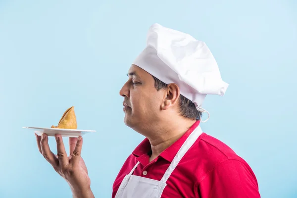 Indio macho chef degustación indio snack samosa, asiático macho chef cocinero y comida en plato — Foto de Stock