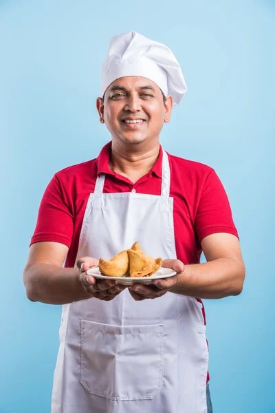 Indian male chef tasting indian snack samosa, asian male chef cook and food in plate — Stock Photo, Image