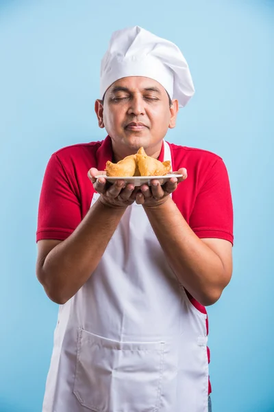 Indian male chef tasting indian snack samosa, asian male chef cook and food in plate — Stock Photo, Image