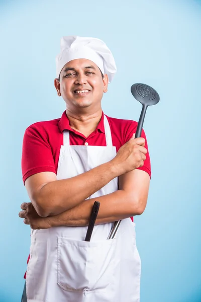 Young Chef Holding spoon skimmer and wooden spoon Isolated On blue Background — Stock Photo, Image