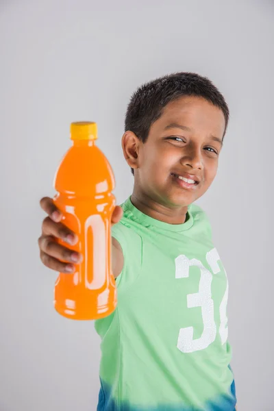 Indiase jongen met koud drankje fles, Aziatische jongen houden koud drankje fles, kleine jongen en koud drankje, Indiase schattige jongen houden mango sap of sinaasappelsap fles — Stockfoto