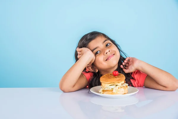 Schattig Indisch meisje eten hamburger, kleine Aziatische meisje en Hamburger, geïsoleerd over gele achtergrond — Stockfoto