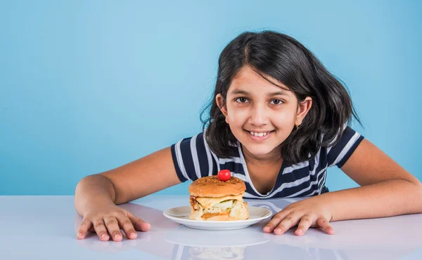 Schattig Indiase meisje eten hamburger, klein Aziatisch meisje en Hamburger, geïsoleerd op kleurrijke achtergrond — Stockfoto