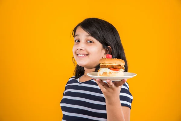 Schattig Indiase meisje eten hamburger, klein Aziatisch meisje en Hamburger, geïsoleerd op kleurrijke achtergrond — Stockfoto