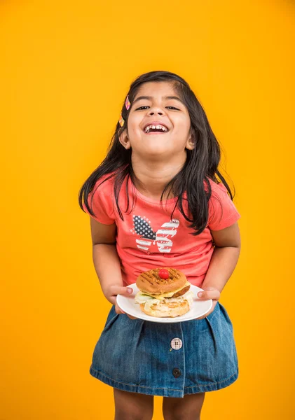 Schattig Indisch meisje eten hamburger, kleine Aziatische meisje en Hamburger, geïsoleerd over gele achtergrond — Stockfoto