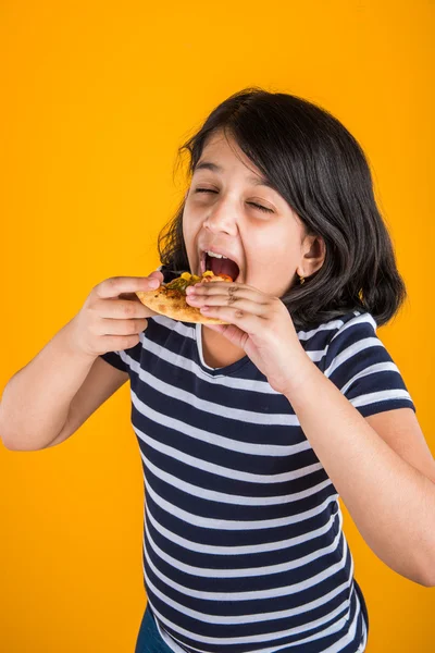 Portret van leuk Indiase meisje pizza eten op gele achtergrond — Stockfoto