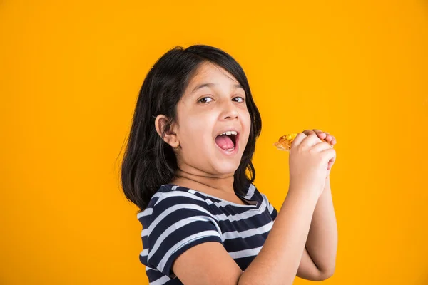 可爱的印度女孩的肖像吃比萨在黄色背景 — 图库照片