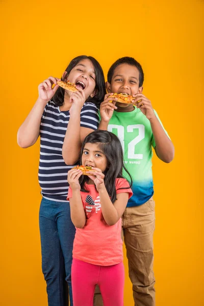 Drie of 3 Indische Kids pizza over gele achtergrond — Stockfoto