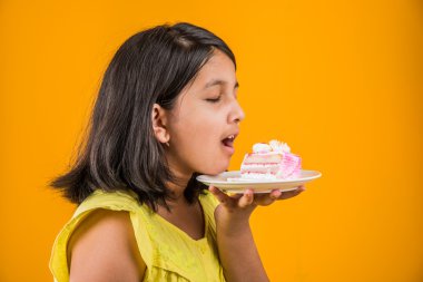 kek ya da pasta, kek, kız sarı arka plan üzerinde çilek pasta yemek yeme sevimli küçük kız yemek Hint çocuk portresi