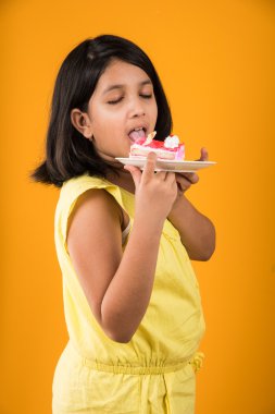 kek ya da pasta, kek, kız sarı arka plan üzerinde çilek pasta yemek yeme sevimli küçük kız yemek Hint çocuk portresi