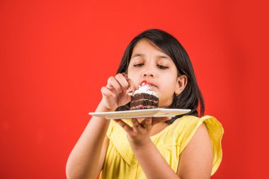 hint çocuk pasta veya pasta yeme portresi, sevimli küçük kız pasta yeme, renkli arka plan üzerinde çikolatalı kek veya pasta yeme kız