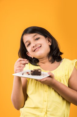 hint çocuk pasta veya pasta yeme portresi, sevimli küçük kız pasta yeme, renkli arka plan üzerinde çikolatalı kek veya pasta yeme kız