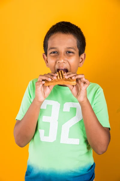 Indian Kid eten sandwich, Aziatische jongen en sandwich, Indische jongen tonen sandwich, schattige Afrikaanse jongen tonen sandwich op gele achtergrond — Stockfoto