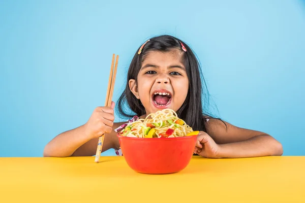 Gelukkig Aziatische kind eten heerlijke noodle, klein Indiaas meisje noedels eten in rode kom — Stockfoto