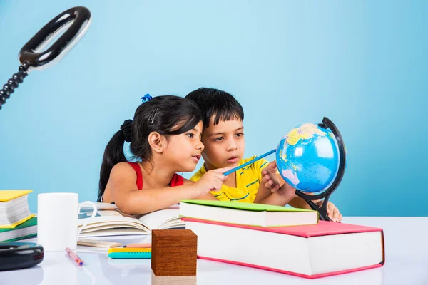 Indiase jongen en meisje studeren met globe op studielijst, Aziatische kinderen studeren, Indiase kinderen studeren geografie, kinderen doen van huiswerk of thuiswerk, twee kinderen studeren op tafel — Stockfoto