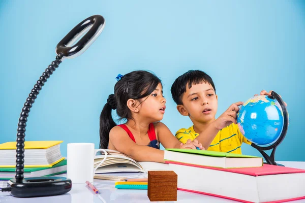 Niño y niña indios que estudian con el globo en la mesa de estudio, niños asiáticos que estudian, niños indios que estudian geografía, niños que hacen tareas o trabajo en casa, dos niños que estudian en la mesa — Foto de Stock