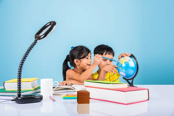 Niño y niña indios que estudian con el globo en la mesa de estudio, niños asiáticos que estudian, niños indios que estudian geografía, niños que hacen tareas o trabajo en casa, dos niños que estudian en la mesa — Foto de Stock