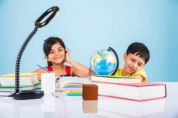 Niño y niña indios que estudian con el globo en la mesa de estudio, niños asiáticos que estudian, niños indios que estudian geografía, niños que hacen tareas o trabajo en casa, dos niños que estudian en la mesa — Foto de Stock