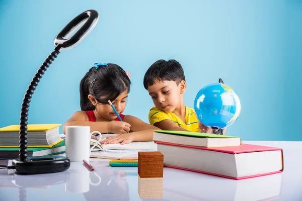 Niño y niña indios que estudian con el globo en la mesa de estudio, niños asiáticos que estudian, niños indios que estudian geografía, niños que hacen tareas o trabajo en casa, dos niños que estudian en la mesa — Foto de Stock