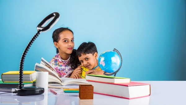 cute indian kids studying, smart asian girl and boy doing home work, indian siblings studying, indian small girl helping her brother in doing homework