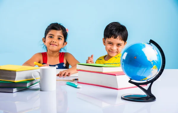 Niño y niña indios que estudian con el globo en la mesa de estudio, niños asiáticos que estudian, niños indios que estudian geografía, niños que hacen tareas o trabajo en casa, dos niños que estudian en la mesa — Foto de Stock