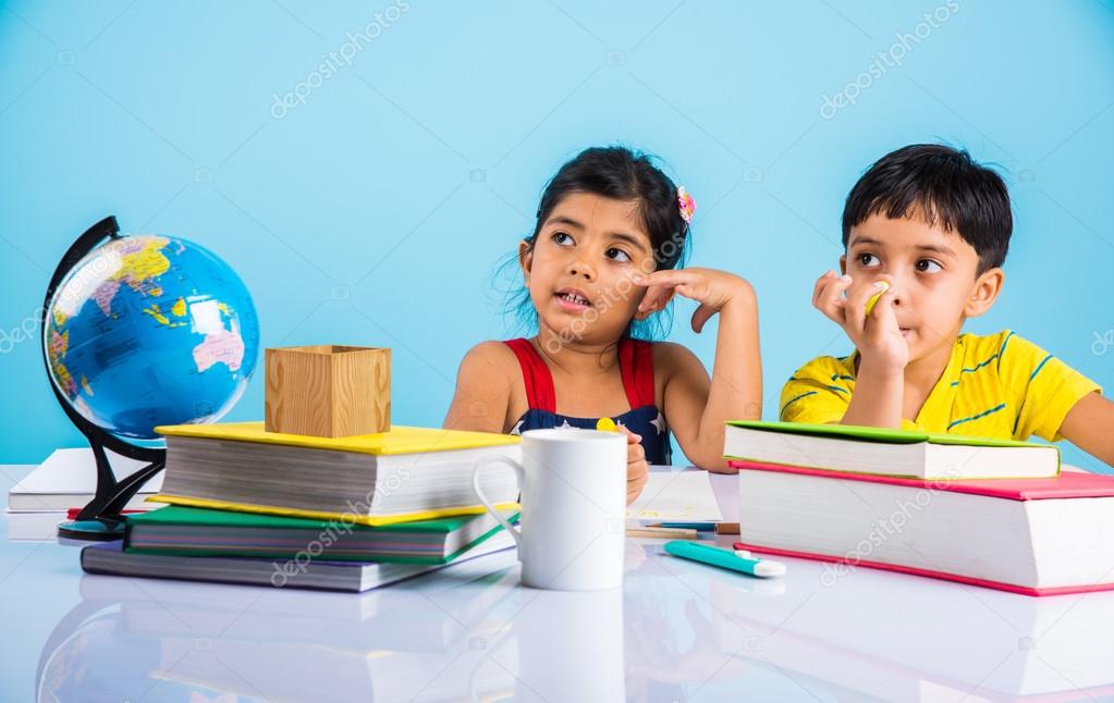 Indian boy and girl studying with globe on study table, asian kids