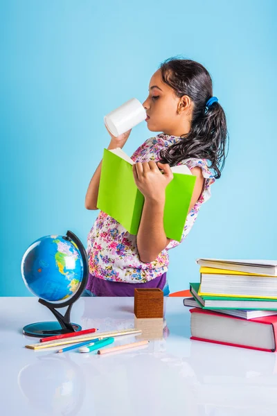 Educación y concepto de hogar - estudiante estresada chica con libros, niña india niño cansado de estudiar o hacer tareas, chica asiática estudiando y estresado, con globo juguete y taza de café — Foto de Stock