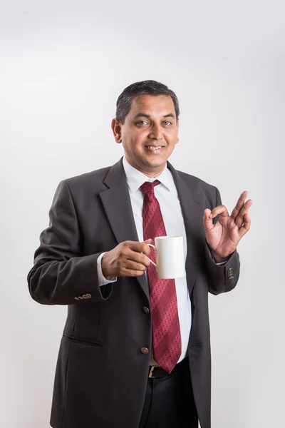 Uomo d'affari indiano che beve caffè o tè, uomo d'affari asiatico e caffè o tè, uomo d'affari che beve caffè in una grande tazza bianca, isolato su sfondo bianco, vista laterale — Foto Stock