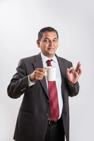 Indian businessman having coffee or tea, asian businessman and coffee or tea, businessman drinking coffee in big white cup, isolated over white background, side view — Stock Photo, Image