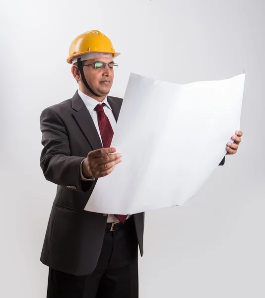 Empresario indio sosteniendo un plano, vistiendo sombrero duro amarillo, aislado sobre fondo blanco —  Fotos de Stock