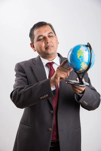 Porträtt av en indisk affärsman som innehar en jordglob-modell, isolerad på vit — Stockfoto