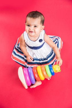 Kırmızı arka plan üzerinde sevimli küçük Hint bebek kız oynamak oyuncaklar, Hint bebek kız oynamaktan, Asya bebek oyun oynarken Hint yürümeye başlayan çocuk