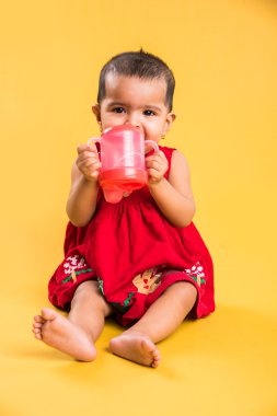 Kırmızı arka plan üzerinde sevimli küçük Hint bebek kız oynamak oyuncaklar, Hint bebek kız oynamaktan, Asya bebek oyun oynarken Hint yürümeye başlayan çocuk