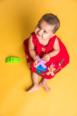 Kırmızı arka plan üzerinde sevimli küçük Hint bebek kız oynamak oyuncaklar, Hint bebek kız oynamaktan, Asya bebek oyun oynarken Hint yürümeye başlayan çocuk