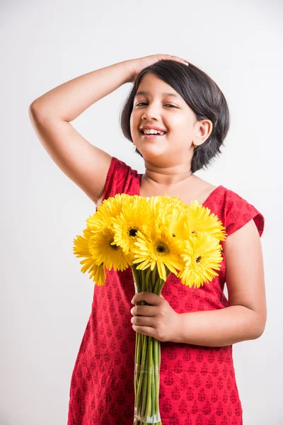 indian small girl holding bouquet of yellow gerbera flowers, isolated over white background, indian girl and flowers, asian girk holding flowers