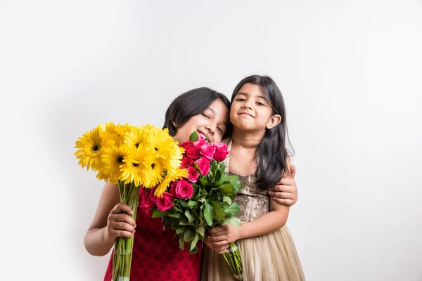 Two cute indian little girls holding flower bouquet, two small girls with gerbera and rose bouquet, isolated on white — Stock Photo, Image