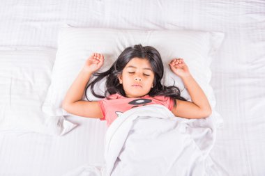 sevimli Hint beyaz yastık üzerinde küçük Asyalı kız yatak uyku uyuyan kız